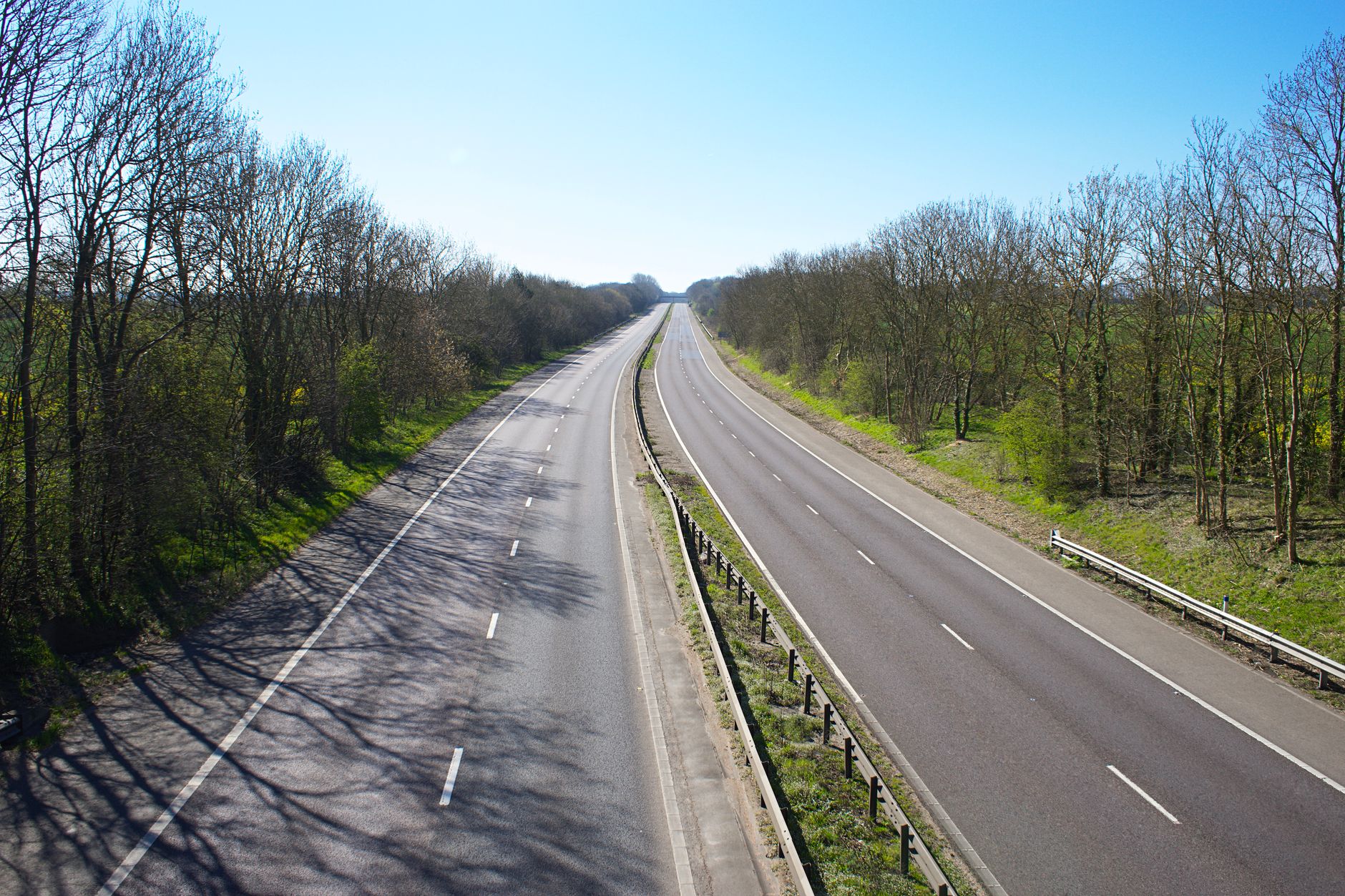 An empty dual carriageway with two lanes each way separated by a central barrier