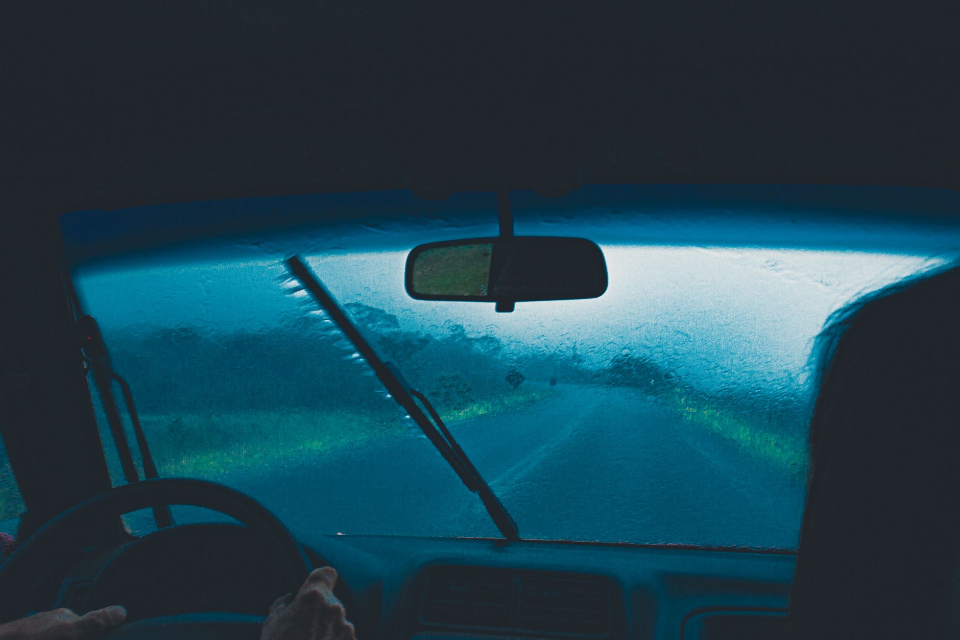 The view through a rain-soaked windscreen from inside a car, the exact conditions where most driving mistakes turn expensive