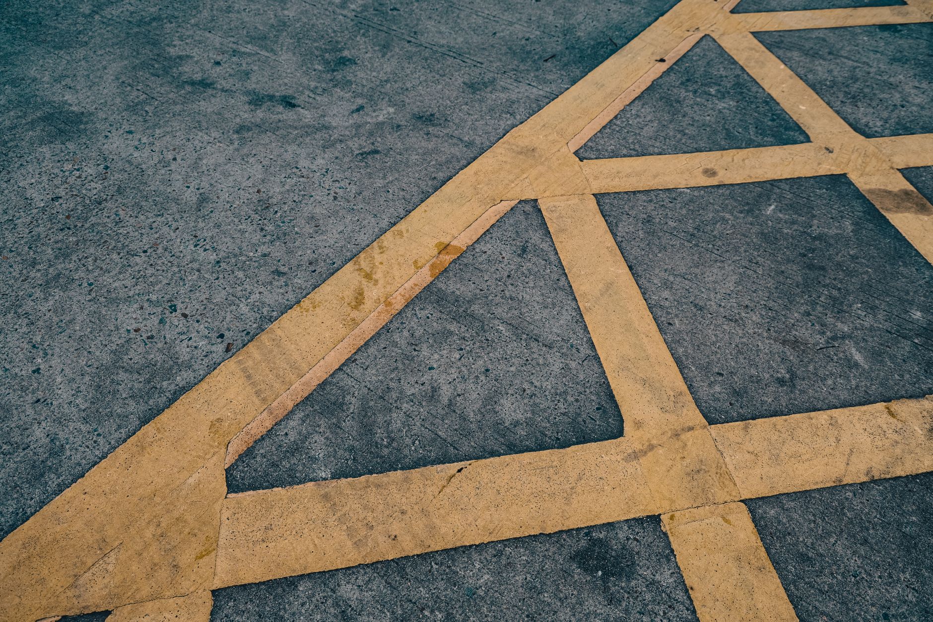 Yellow hatched road markings painted across grey asphalt