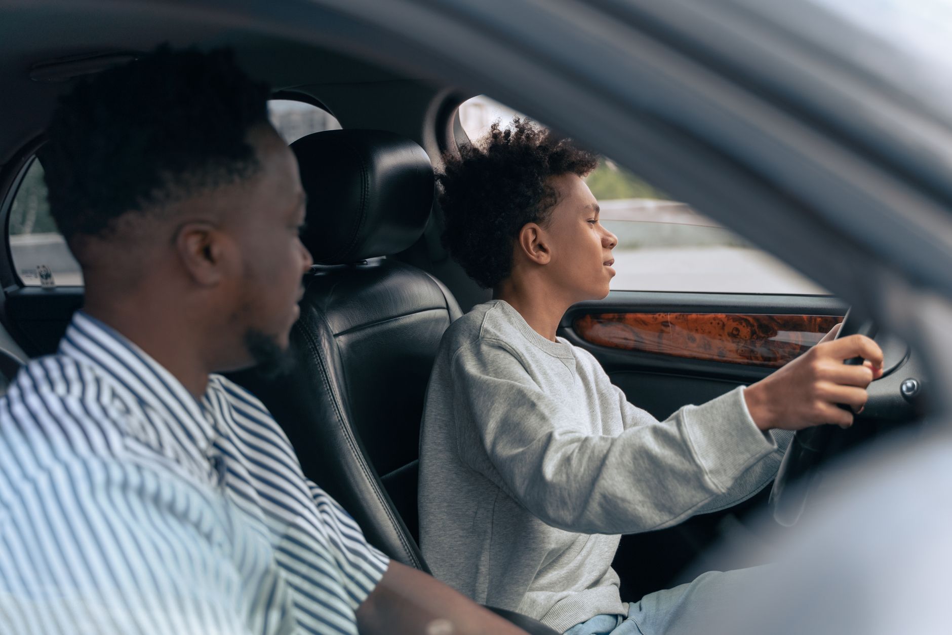 A parent in the passenger seat supervising a learner driver during family practice